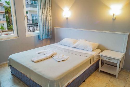 a bedroom with a bed with two towels on it at Adora Pansiyon in Side