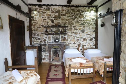 a room with two beds and a fireplace at Hotel Nasho Vruho in Berat