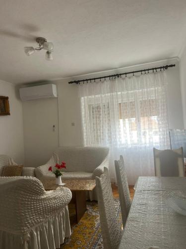 a dining room with a table and chairs and a window at Stan Uljarević in Zlatište
