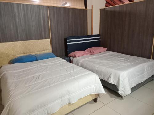 two beds sitting next to each other in a room at Departamento Luque in Luque
