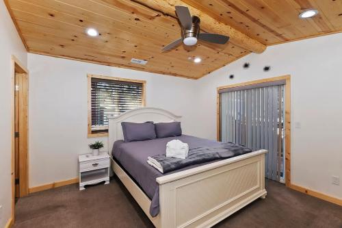 a bedroom with a bed and a ceiling fan at Stylish Elysian Big Bear Cabin w Enclosed backyard in Big Bear City