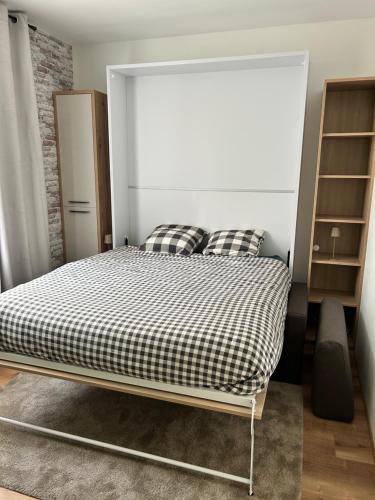 a bedroom with a bed with a black and white blanket at Cocon romantique Jardin de la princesse idéal couple Calme & nature Vosges in Senones