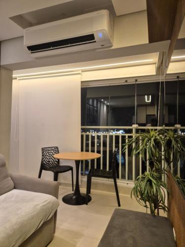 a living room with a table and chairs and a balcony at APTO 42M l 7 km Alphaville in Osasco