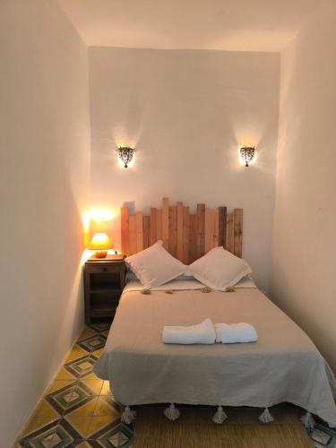 a bedroom with a bed with two towels on it at Riad Louisa in Chefchaouen