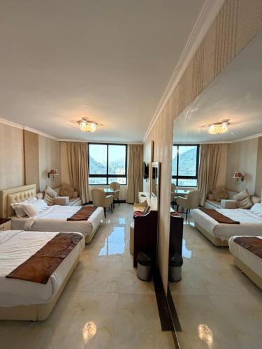 a hotel room with four beds and a living room at Royal Family Hotel in ‘Aţţān