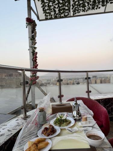 a table with plates of food on a balcony at Royal Family Hotel in ‘Aţţān