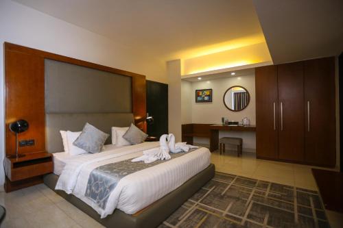 a bedroom with a large bed with towels on it at Sky City Hotel Dhaka in Dhaka