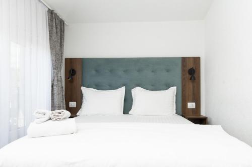 a bedroom with a large bed with white pillows at Kulla e Sahatit - Boutique Hotel in Old Bazaar in Gjakove