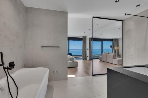 a bathroom with a white tub and a living room at Villa Reina in Makarska