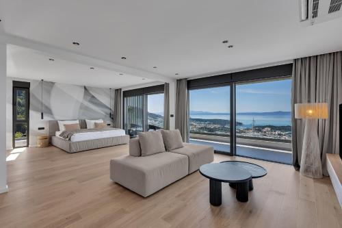 a living room with a couch and a bed and windows at Villa Reina in Makarska