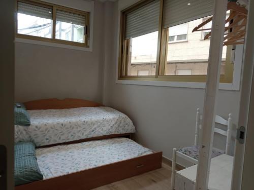 a bedroom with a bunk bed and two windows at D'Canteira in Redondela
