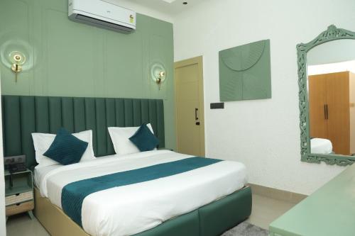 a bedroom with a large bed and a mirror at Divine Hotel in Karnal