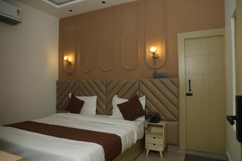 a bedroom with a large bed with a large headboard at Divine Hotel in Karnal