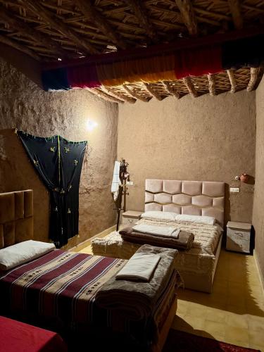 a bedroom with two beds in a room at Gite d étape Khettara Oasis in Er Rachidia