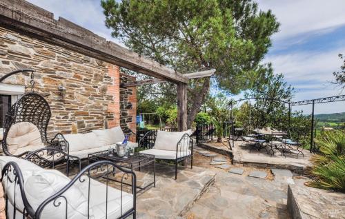 an outdoor patio with chairs and a stone wall at Awesome Home In Rigarda in Rigarda