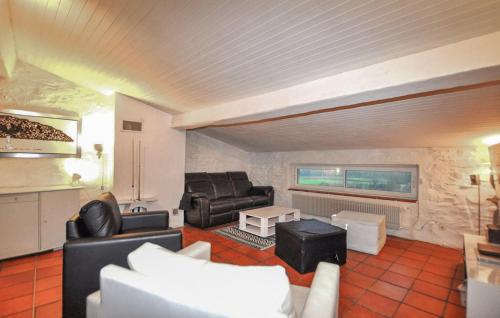 a living room with leather furniture and a fireplace at Awesome Home In Rigarda in Rigarda