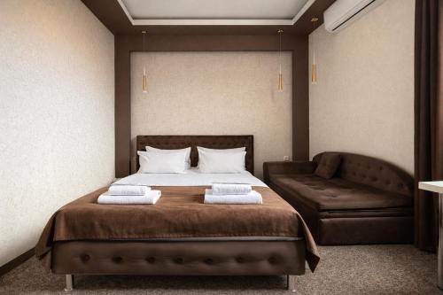 a bedroom with a bed with two towels on it at DavidL Hotel Tbilisi in Tbilisi City