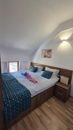 a bedroom with a bed with a blue comforter at Panorama Apartment in Mavrovo
