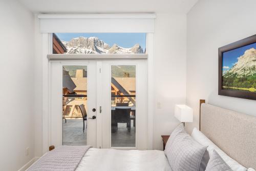 a bedroom with a bed and a view of a table at Spectacular Penthouse With Amazing Views, Indoor Pool and Hot tub in Canmore