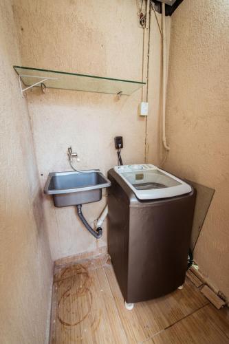 a small bathroom with a sink and a toilet at Casa em Jacumã com Piscina, 5 Suítes e Fliperama in Conde