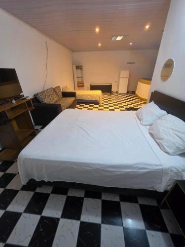 a bedroom with a large bed and a living room at Ypane Residencial in Ypane