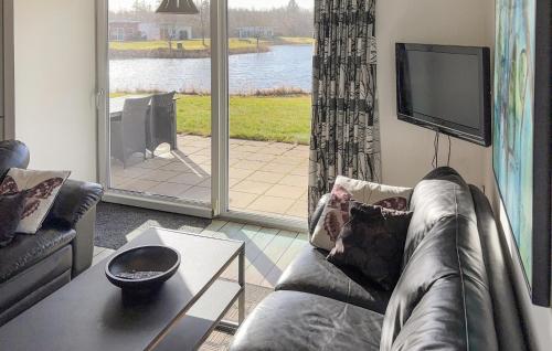 a living room with a couch and a tv at Stunning Home In Ringkøbing With Wifi in Ringkøbing