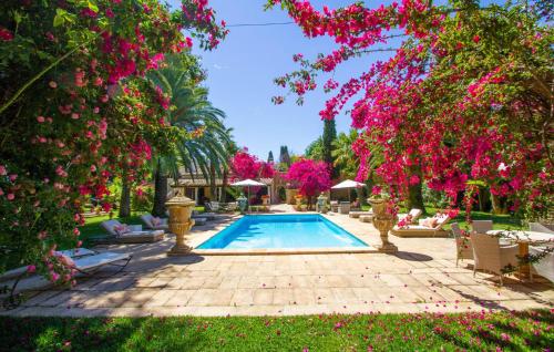 a swimming pool in a garden with pink flowers at Santa Lucia in Binissalem