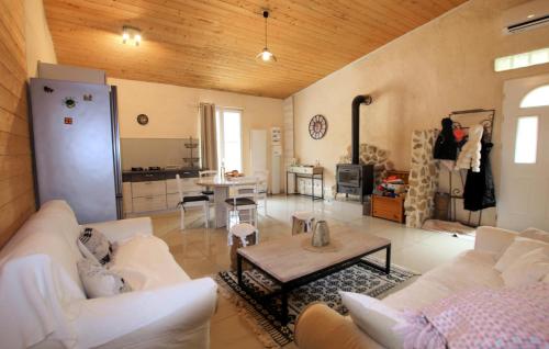 a living room with white couches and a table at Mazet Du Gua in La Pervenche