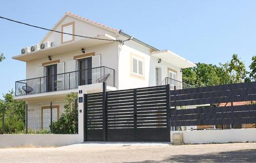 a black fence in front of a white house at Amazing Home In Dugobabe in Dugobabe