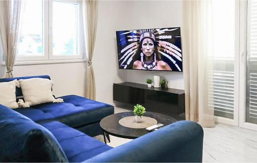 a living room with a blue couch and a table at Amazing Home In Dugobabe in Dugobabe