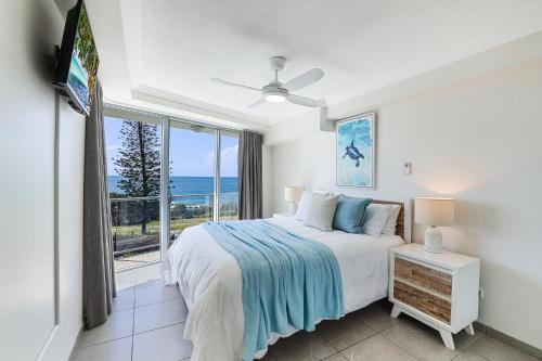 a bedroom with a bed and a view of the ocean at Dwell @ 22, Oceanfront Apartment in Bargara