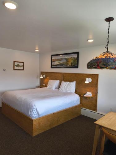 a bedroom with a large bed with white sheets at Sara Placid Inn & Suites in Saranac Lake