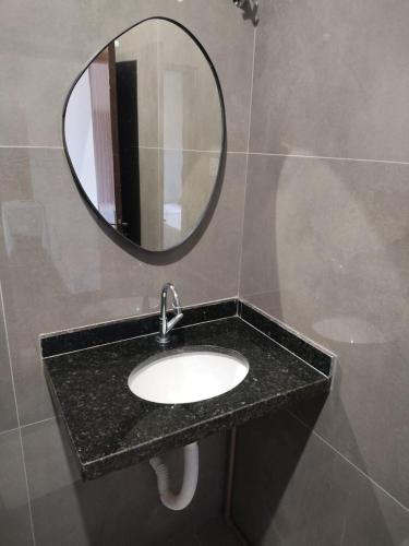 a bathroom with a sink and a mirror at Fênix Hotel Colinas do Tocantins in Colinas do Tocantins