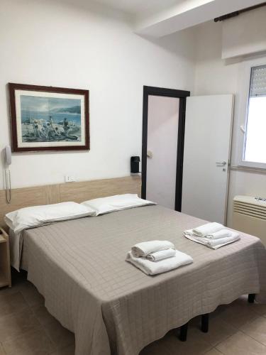 a bedroom with two beds with towels on them at Hotel Continental in Pesaro