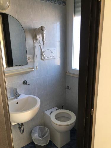 a bathroom with a white toilet and a sink at Hotel Continental in Pesaro