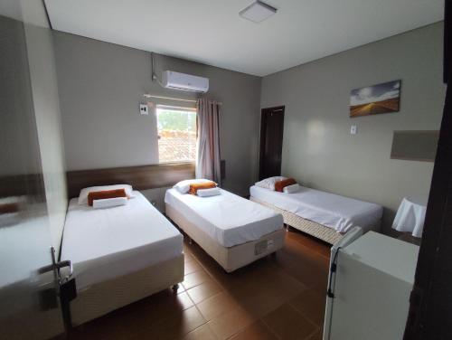 a room with two beds and a window at Fênix Hotel Colinas do Tocantins in Colinas do Tocantins