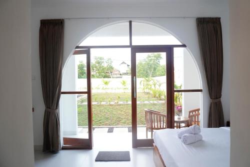 a bedroom with an open door to a garden at Home Riki in Badung