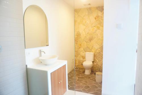 a bathroom with a sink and a toilet at Home Riki in Badung