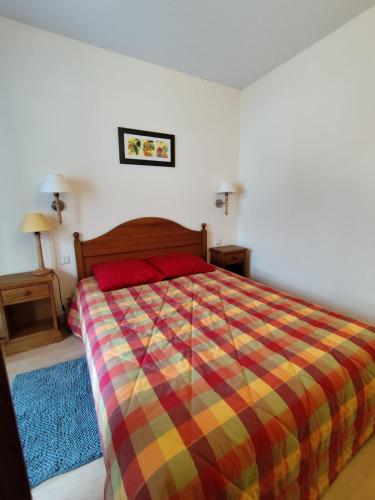 a bedroom with a bed with a colorful comforter at Le Carré Coloré in Ustou