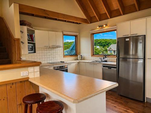 a kitchen with a stainless steel refrigerator and wooden floors at Dragonfly Chalet in Dinner Plain