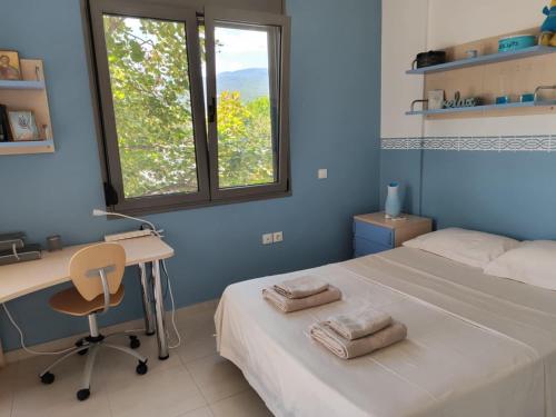 a bedroom with a bed and a desk and a window at Sea & Summit Pool Villa in Platamonas