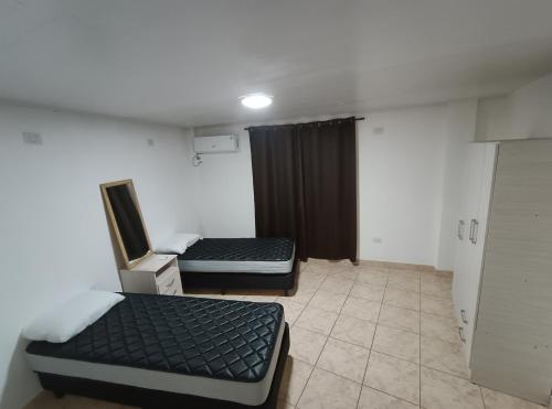 a small room with two beds and a mirror at Departamentos Don Julio in Guaraní