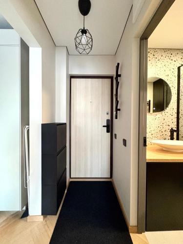 a kitchen with a white door and a black rug at Work & Stay Apartment Klaipėda in Klaipėda