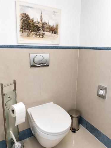 a bathroom with a toilet and a picture on the wall at Hotel Donaustadt Kagran - at Metro U1 in Vienna