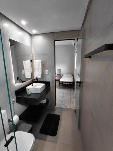 a bathroom with a sink and a mirror and a bed at Nosso Lar casa inteira, completa e independente in Barra do Garças