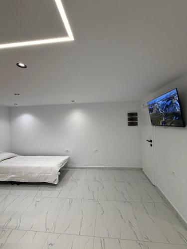 a white room with a bed and a painting on the wall at Happy Stayy in Patza-Kuqani