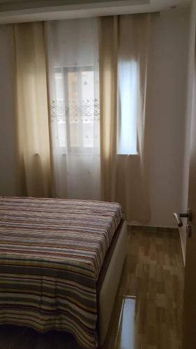 a bedroom with a bed and a window with curtains at Casa Strela Negra in Tarrafal