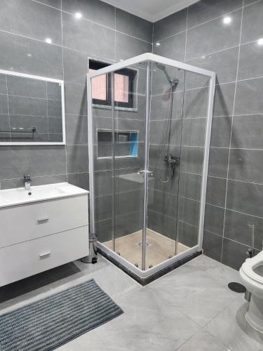 a bathroom with a shower with a sink and a toilet at Casa Strela Negra in Tarrafal