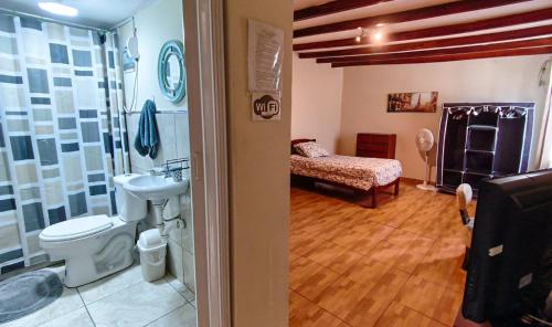 a bathroom with a toilet and a sink in a room at ENHEBRA HOUSE in Lima