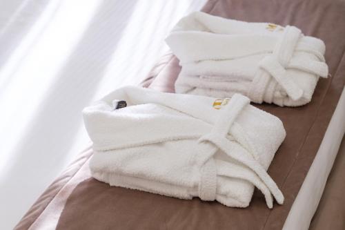 a pile of white towels on a bed at Time Boutique Hotel in Yerevan